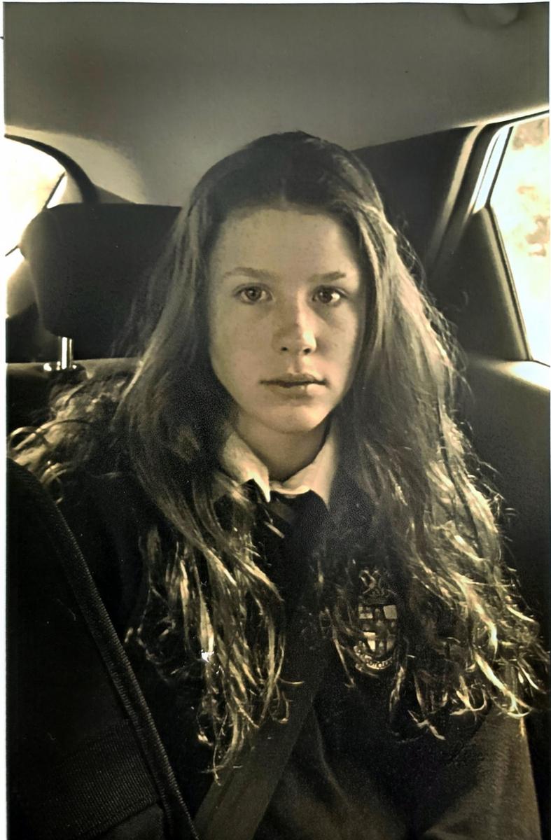 Aideen in her Irish school uniform, sitting in a car